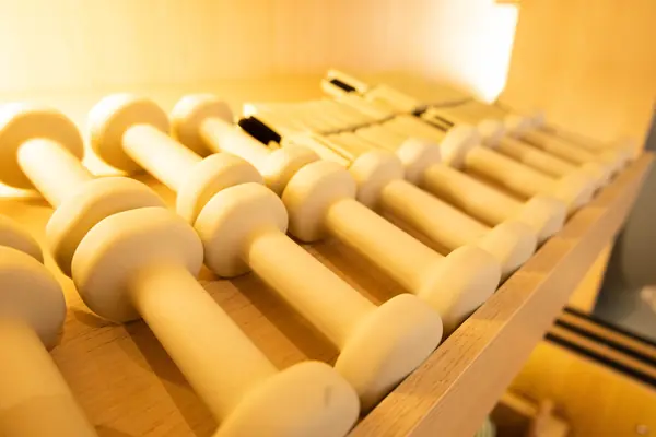 Mancuernas de madera en su repisa iluminada en Balans Studio